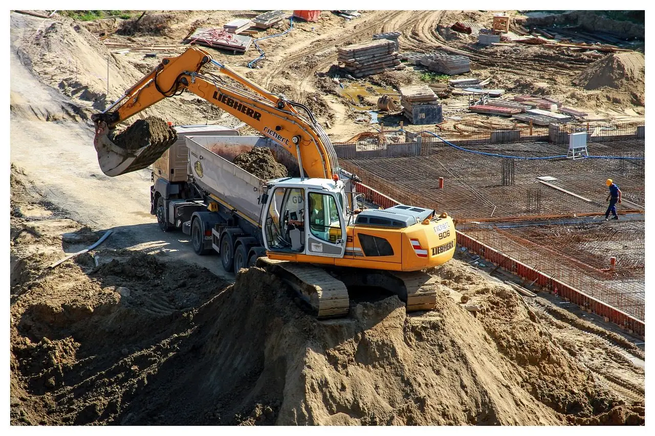 Yellow excavator loading a dump truck
